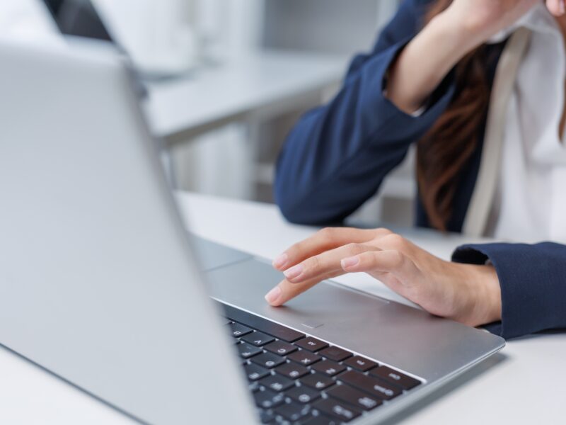 Businesswoman,Using,Laptop,Trackpad,In,Office,Environment,,Working,On,Computer,