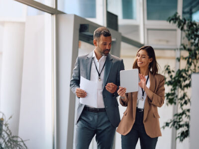 Happy,Businesswoman,And,Her,Colleagues,Working,On,Touchpad,In,The
